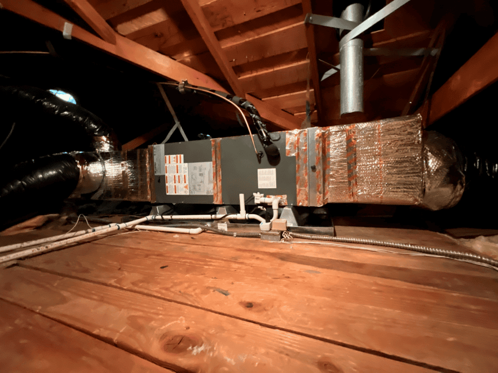 Attic HVAC system with ductwork and insulation in the attic space.
