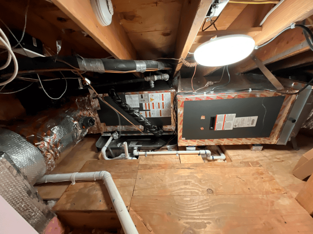 Attic HVAC system with ductwork and furnace for home heating and cooling.